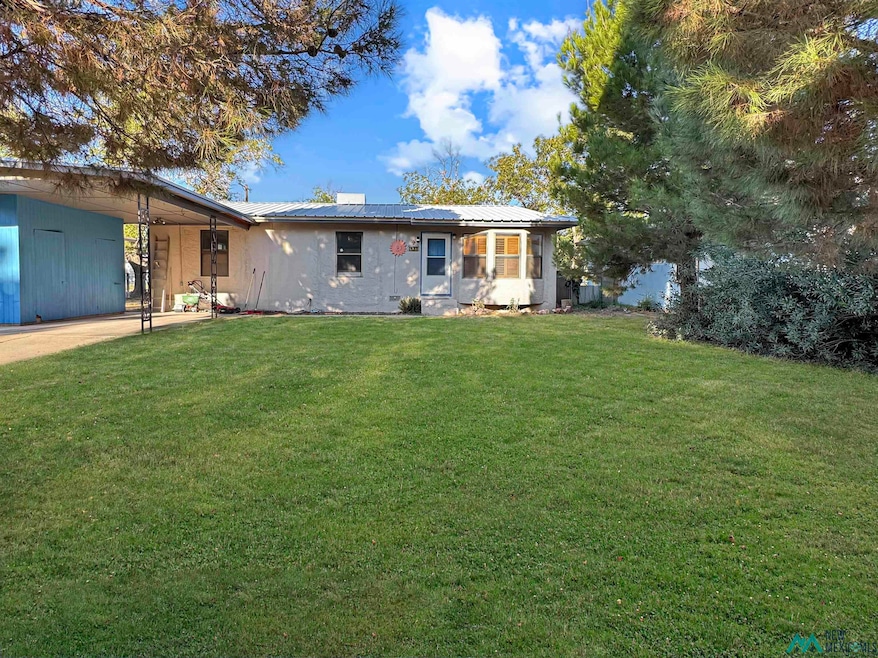 View of front of property featuring a metal roof and a front lawn