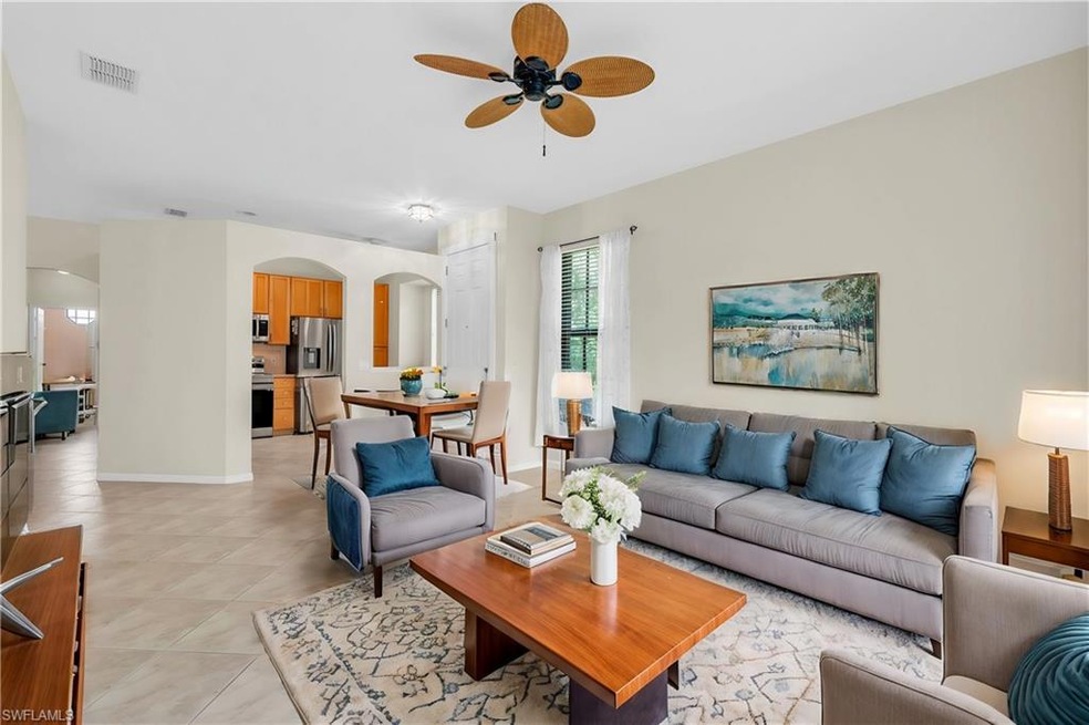 Living room with ceiling fan and light tile patter
