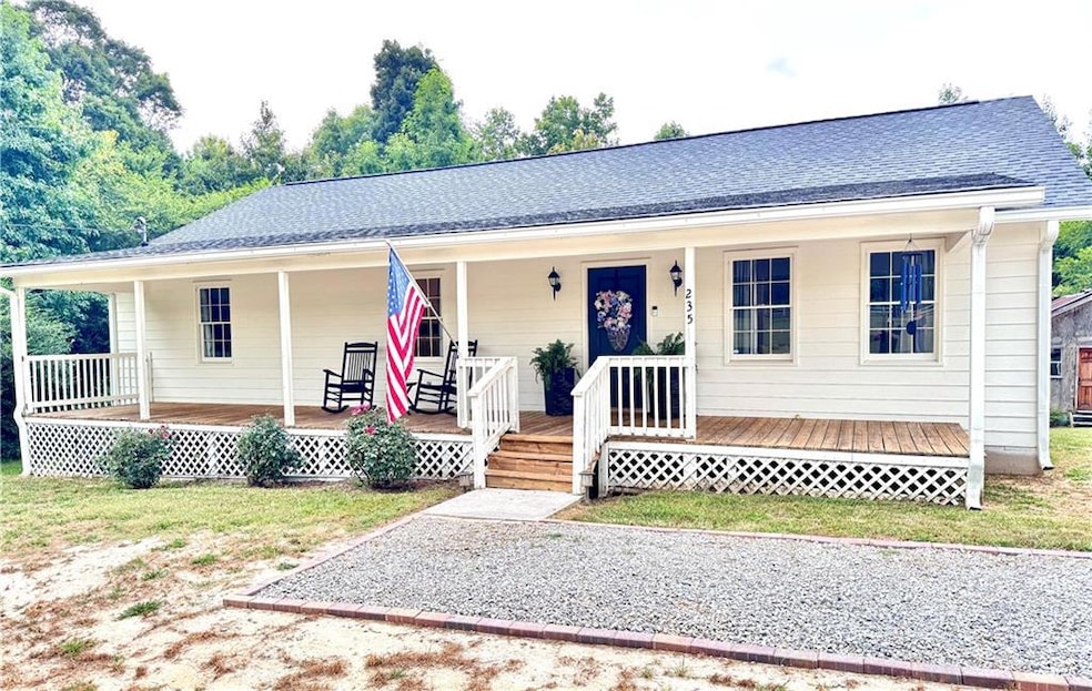 View of front of home with covered porch and roof with shingles
