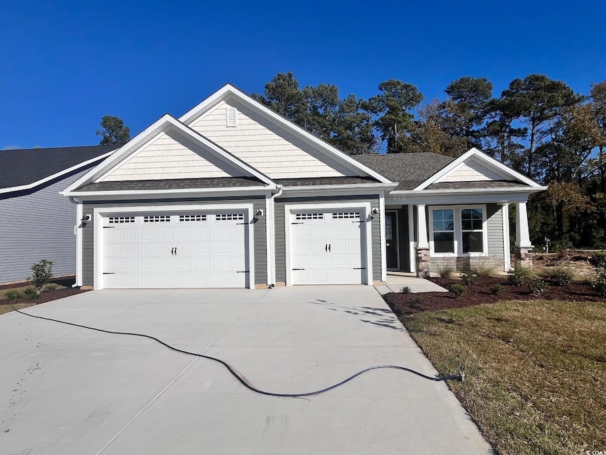 Craftsman house with roof with shingles, concrete driveway, and an attached garage