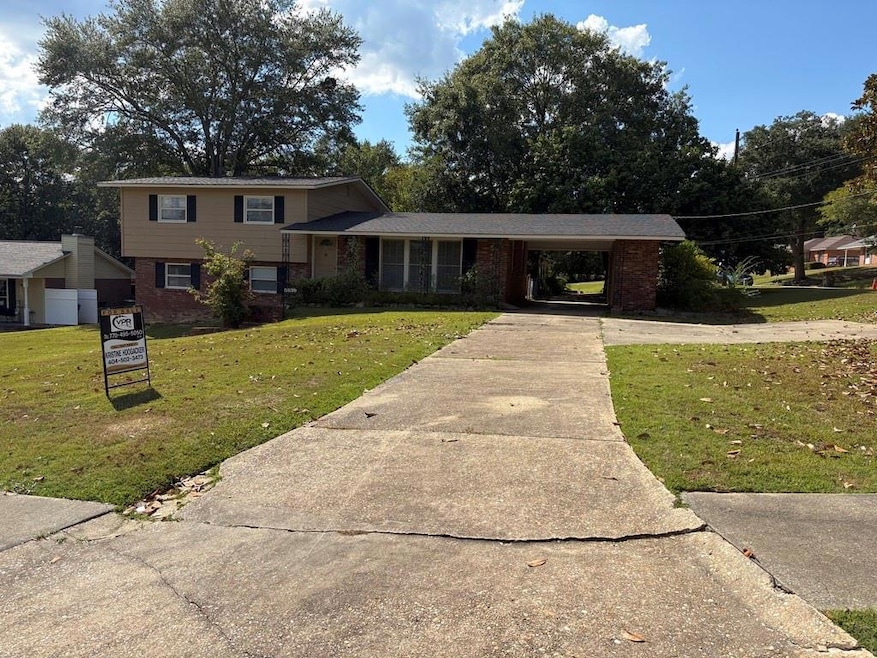 Split-level home with brick siding, a front lawn, and concrete driveway