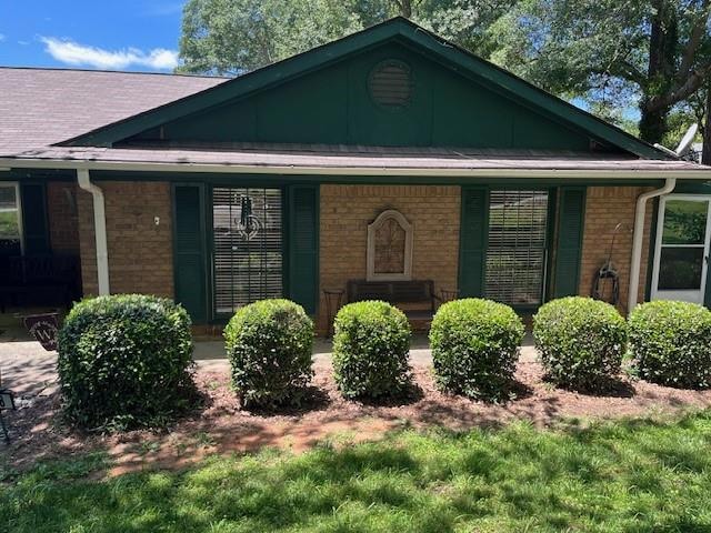 View of front facade featuring brick siding and a porch
