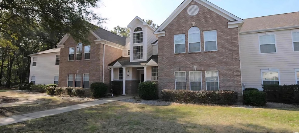 Traditional-style home with brick siding and a front lawn