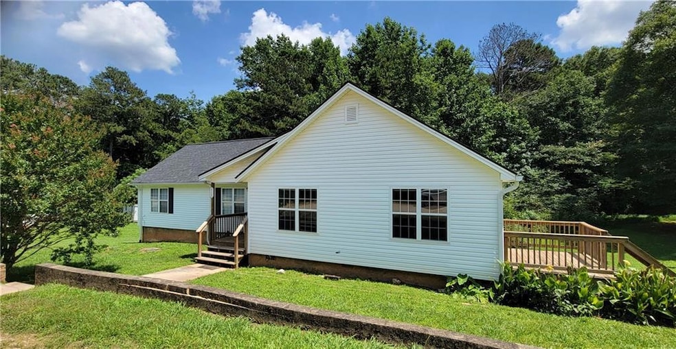 Back of house featuring a lawn, crawl space, and a wooden deck