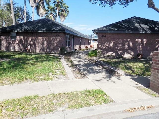 View of property exterior featuring brick siding and roof with shingles