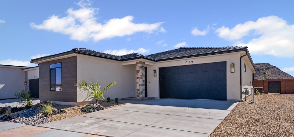 View of front facade with an attached garage, concrete driveway, stucco siding, and a tile roof