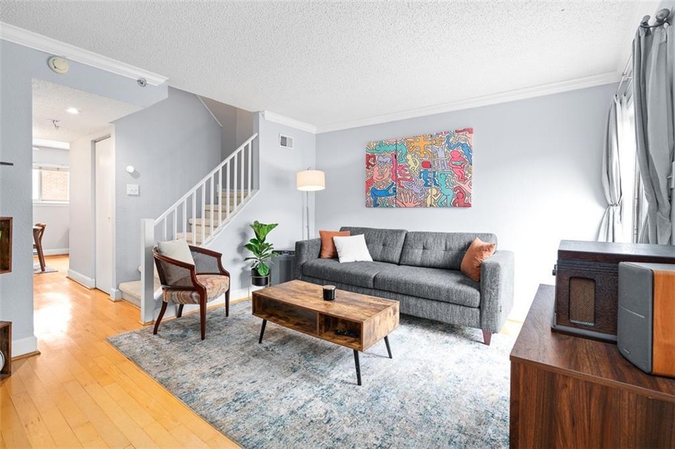 Living room with wood-type flooring, and crown mol