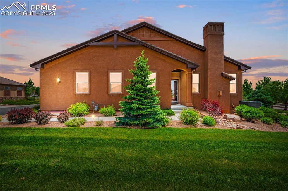 View of front of property with a lawn, stucco siding, and a chimney