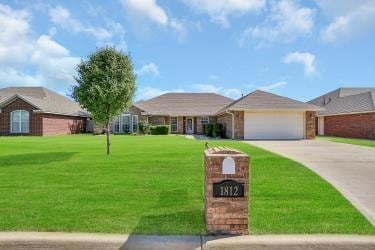 Ranch-style home featuring a garage and a front la