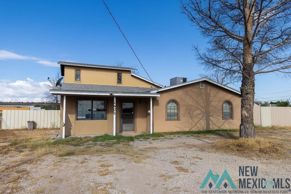 View of front facade featuring covered porch, roof with shingles, and stucco siding