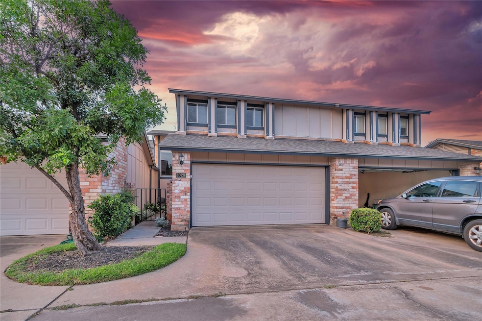 View of property featuring brick siding, concrete