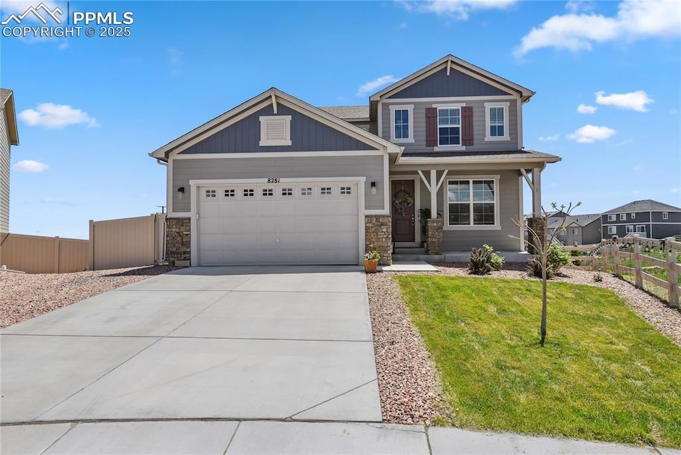 Craftsman house with a garage, driveway, stone siding, and covered porch