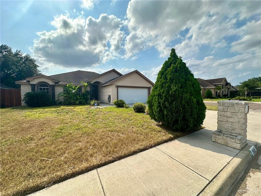 Ranch-style house featuring a front lawn, an attached garage, and brick siding