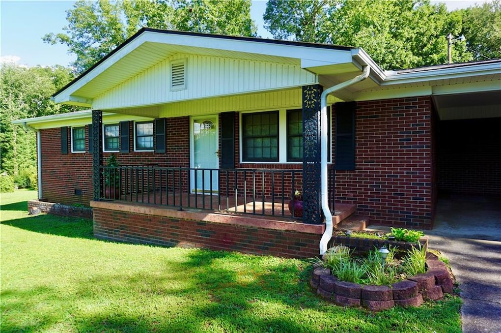 Bungalow-style house with covered porch, brick siding, and a front lawn