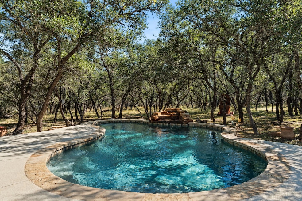 Outdoor pool featuring a patio and view of wooded