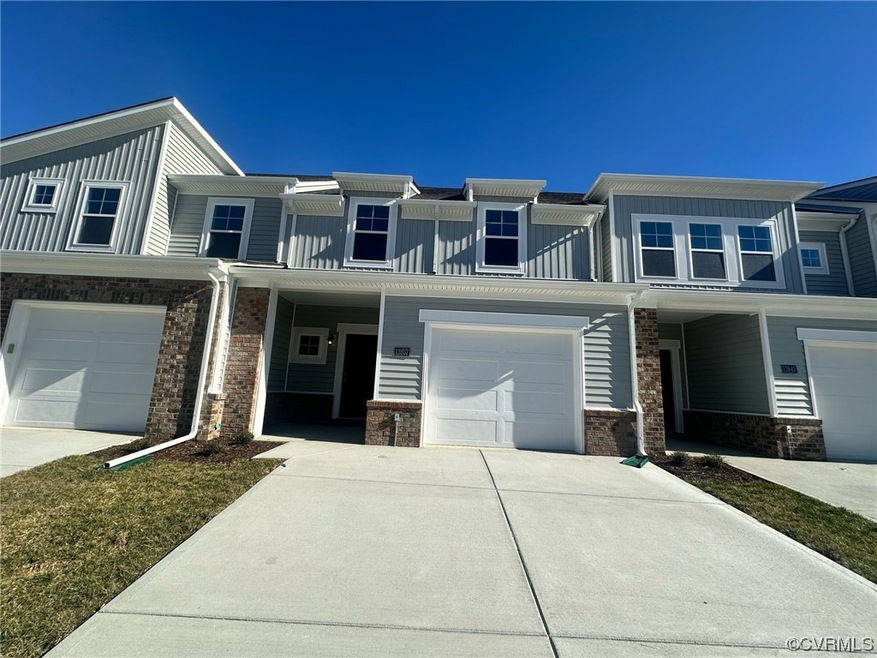 Townhome / multi-family property featuring a garage and a porch