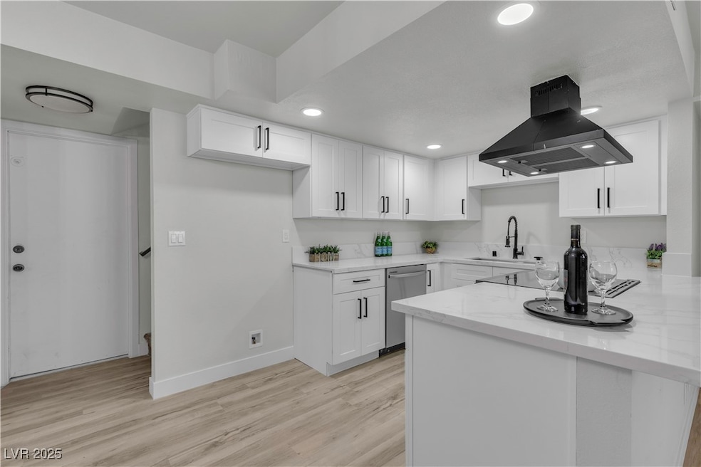 Kitchen with a sink, island range hood, white cabi