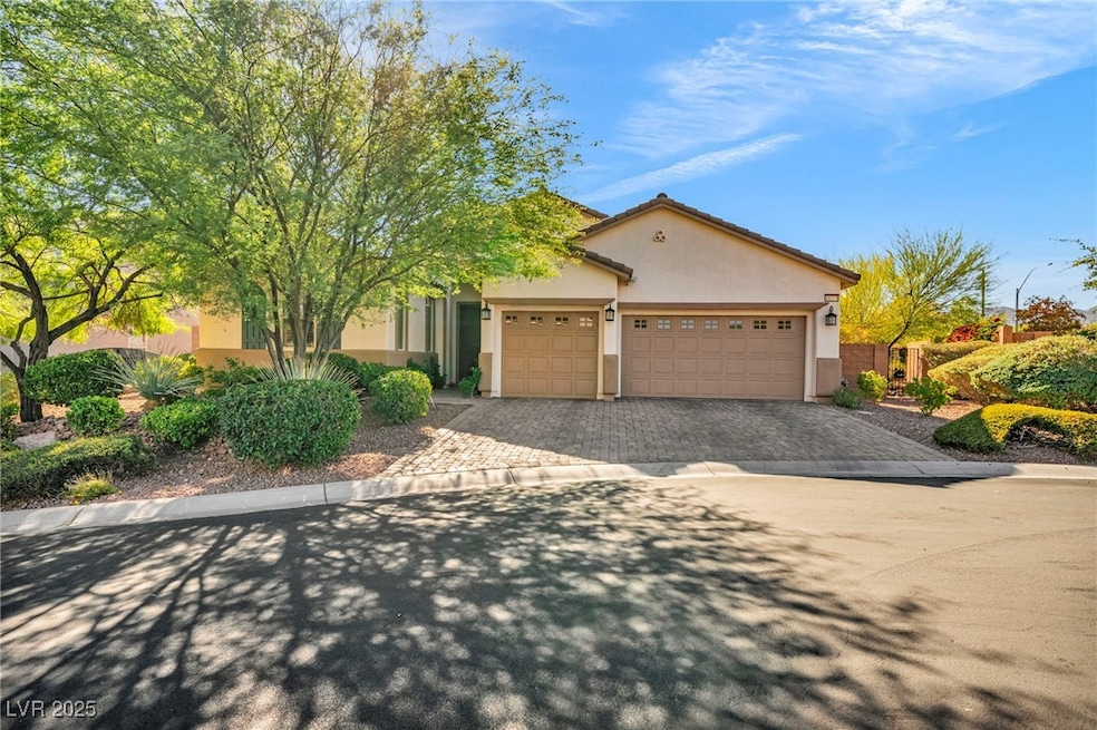View of front of property featuring decorative driveway, a garage, and stucco siding