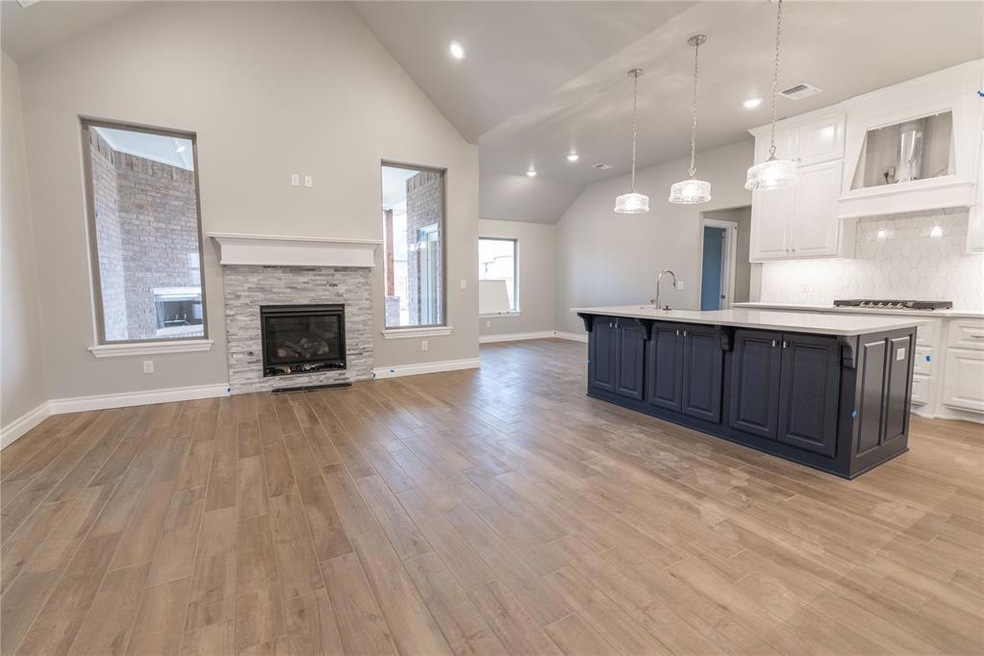 Kitchen with sink, white cabinetry, hanging light 