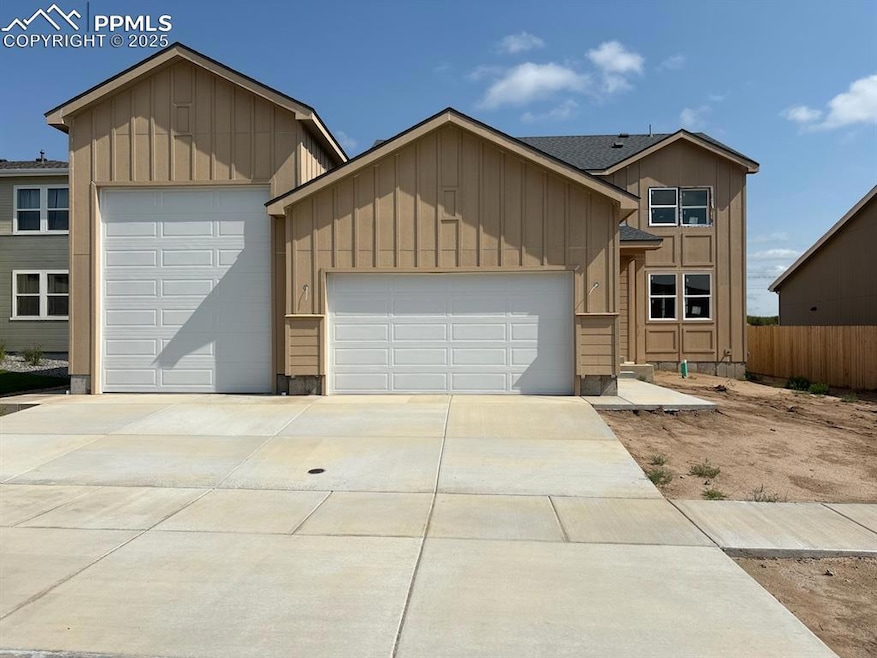 View of front of property with a garage, board and batten siding, and driveway