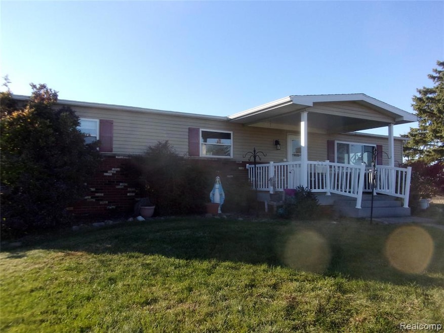 View of front of house featuring a front lawn and a deck