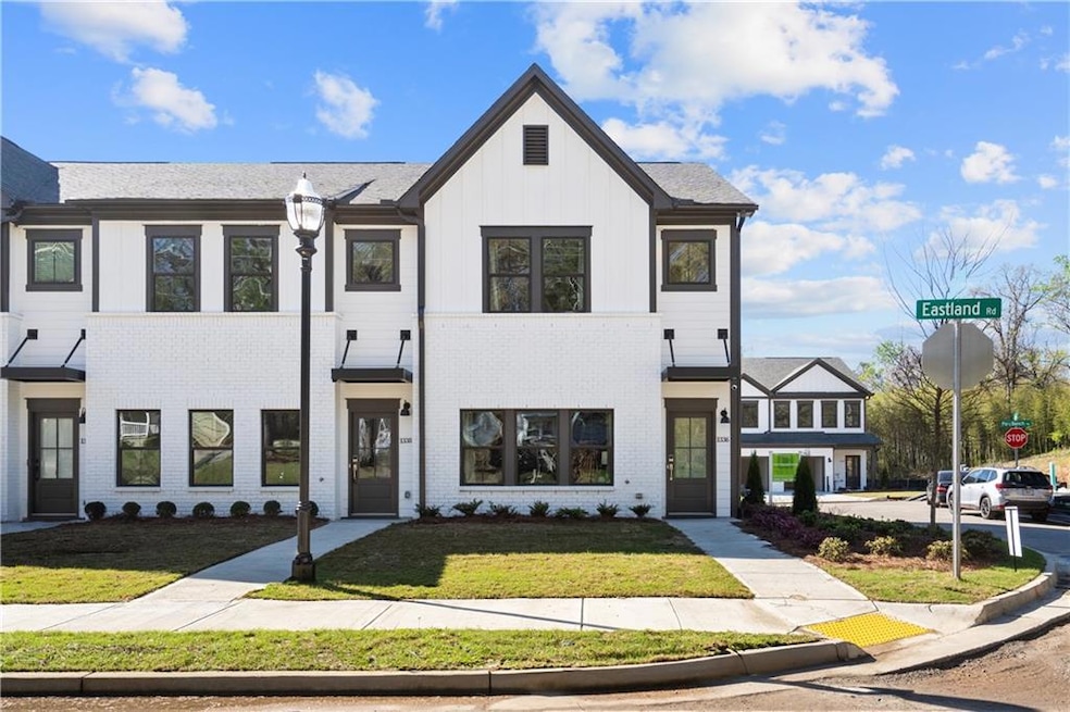 View of front of property with a front yard, board