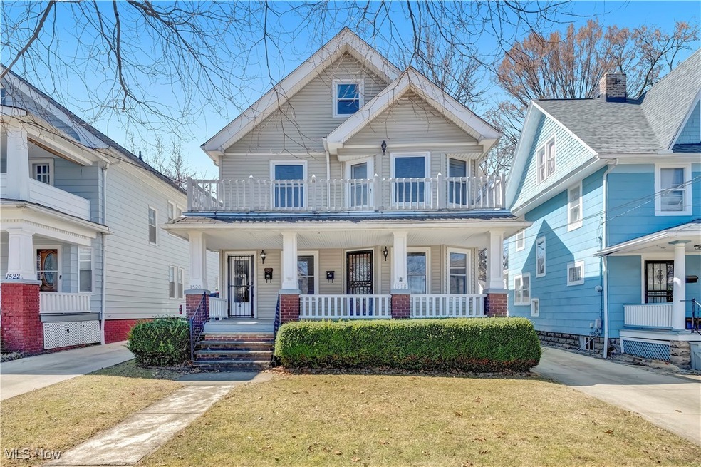 Virtually Staged View of front of home featuring a porch, a balcony, and a front lawn