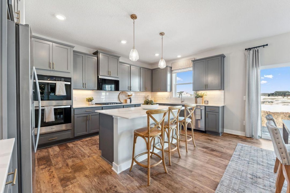 A very impressive kitchen with an equally impressive pantry! Photo of previously built home; finishes, selections, colors, and floorplan to vary.