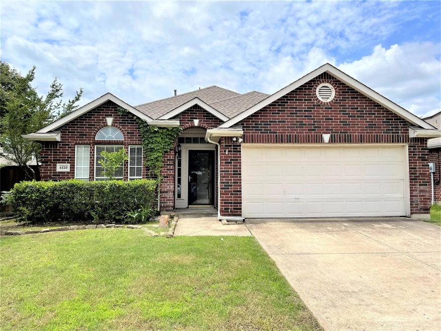 View of front of home with a garage and a front lawn