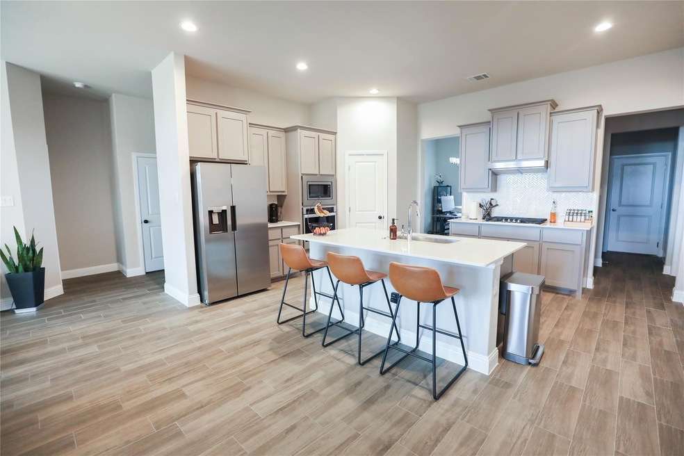 Kitchen featuring a center island with sink, appli