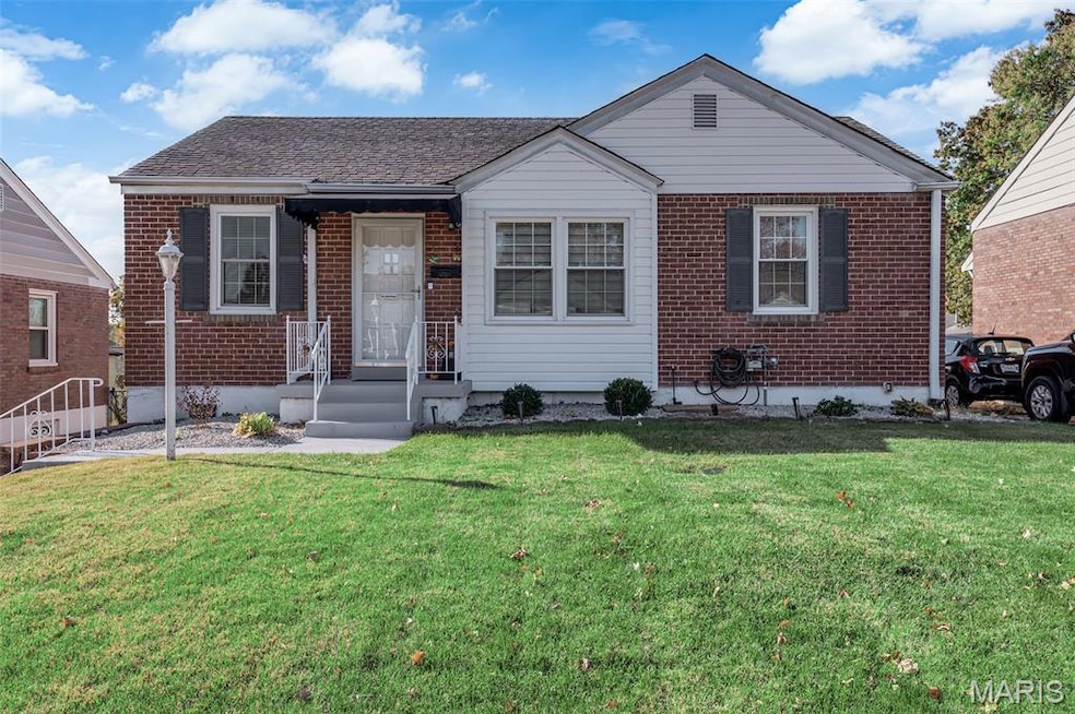 Bungalow featuring brick siding, a front lawn, and roof with shingles