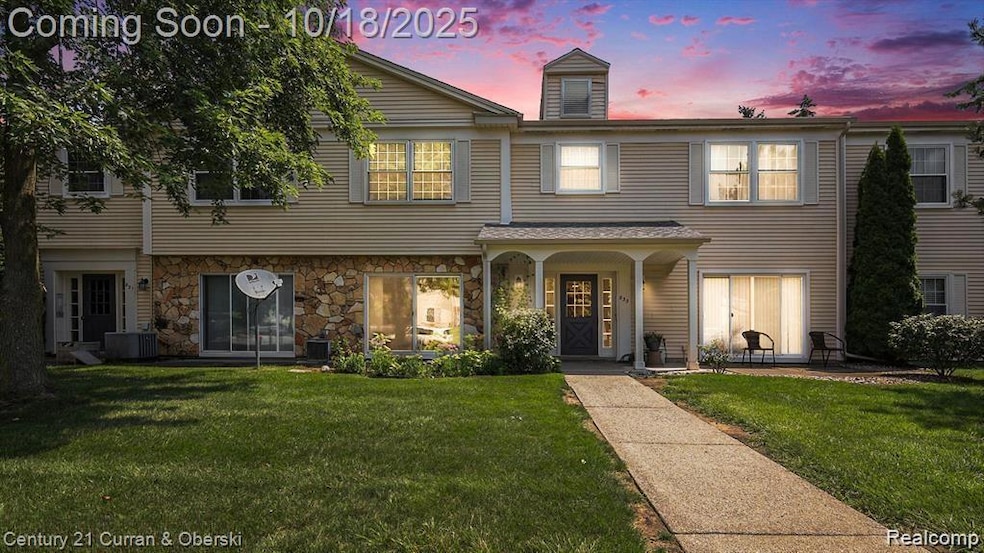 View of front facade with a yard, covered porch, and stone siding