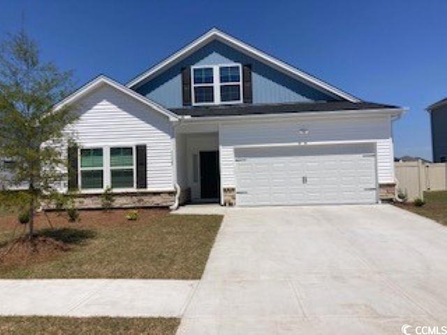 View of front of home with driveway and a garage