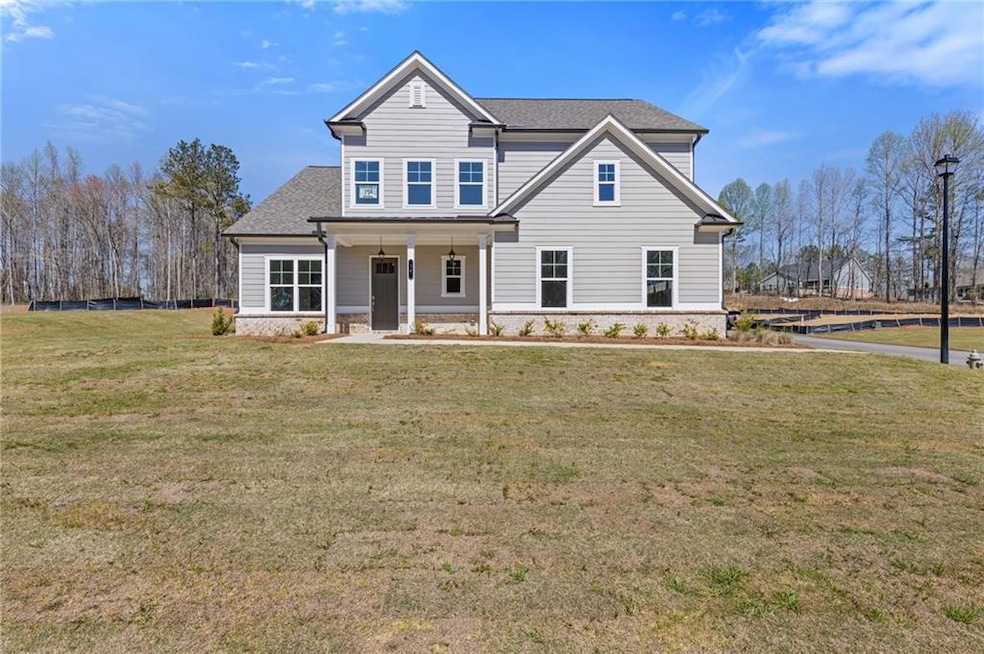 Traditional home featuring a porch, a shingled roof, and a front lawn