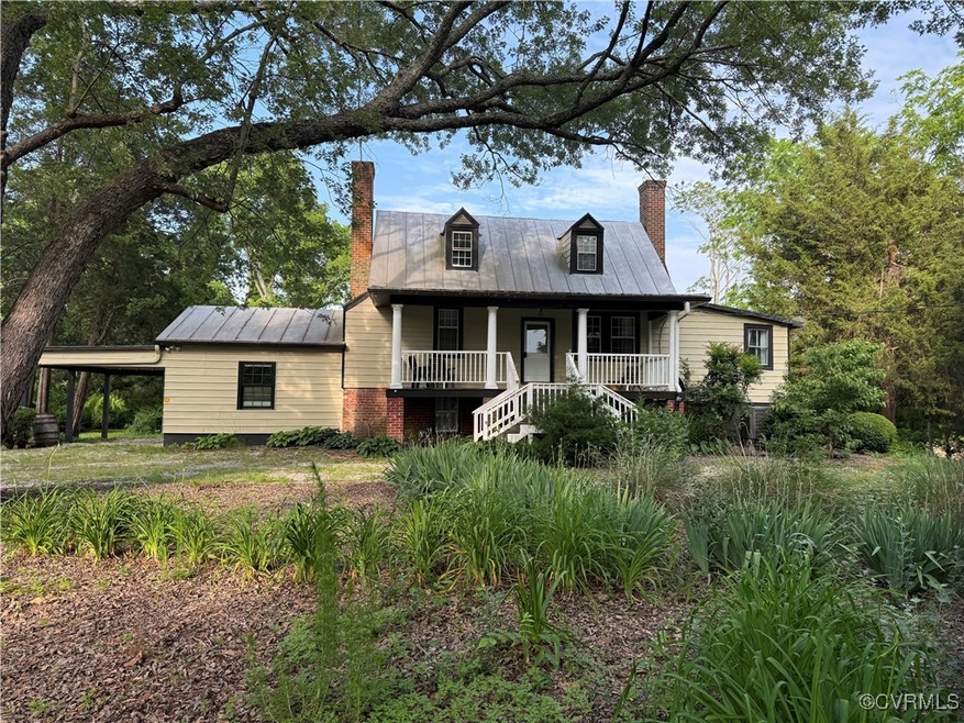 View of front of property with a chimney, covered