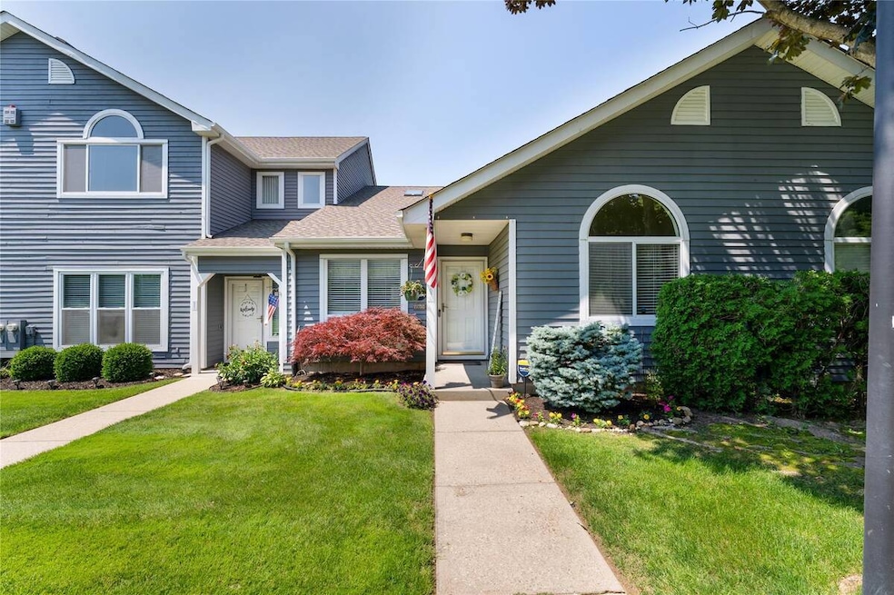 View of front of property featuring a front lawn and a shingled roof