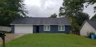 Ranch-style home featuring an attached garage and driveway