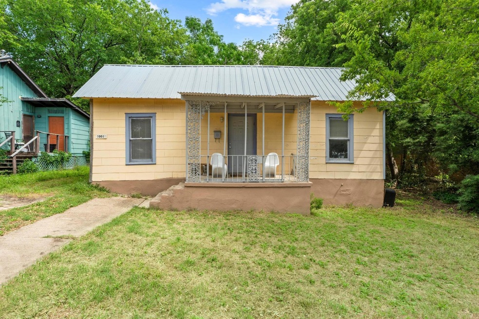 Back of property with covered porch, a yard, and 