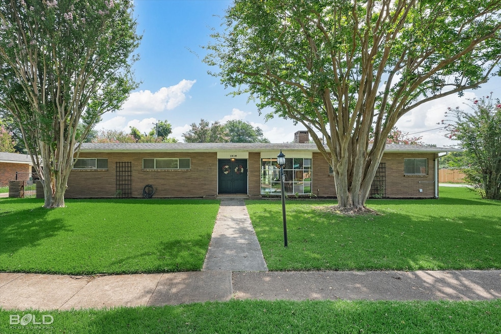 Ranch-style house featuring brick siding, a front lawn, and a chimney
