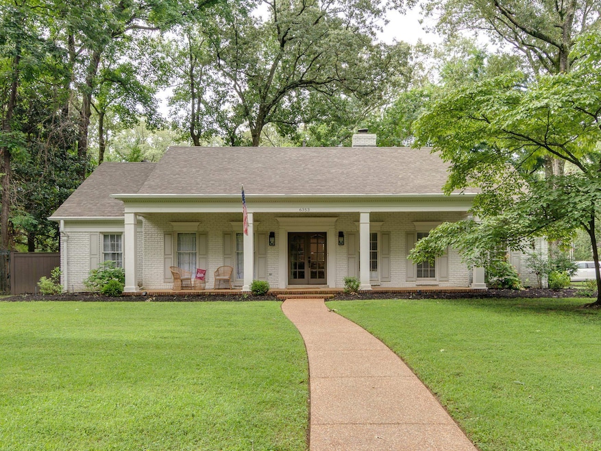 View of front of home with brick siding, covered porch, roof with shingles, a chimney, and french doors
