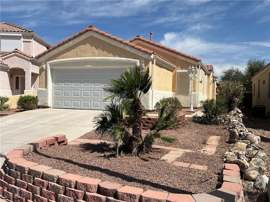 View of front of property featuring a garage, driv