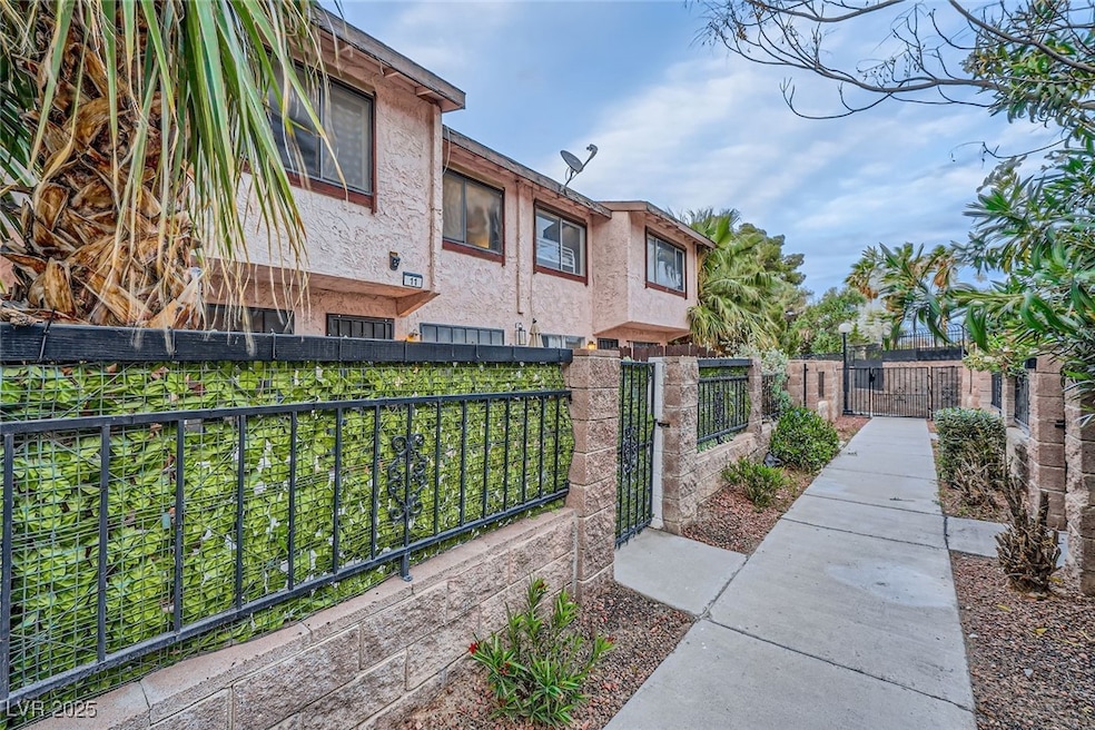 View of home's exterior with stucco siding, a gate