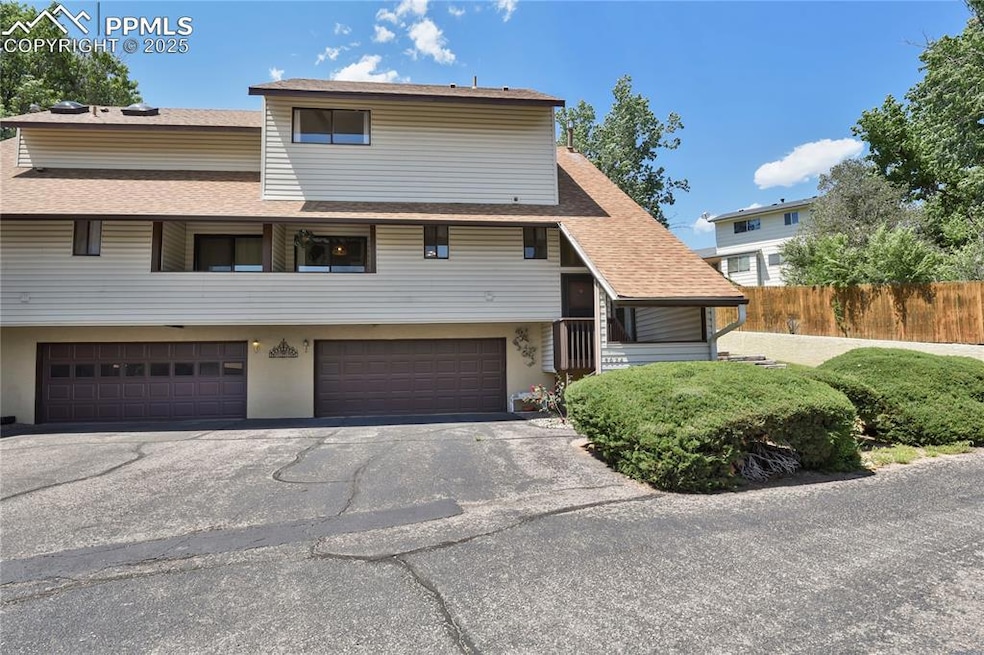 View of front of house featuring a garage, a shingled roof, and driveway