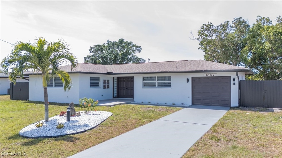 Ranch-style house with stucco siding, driveway, fe