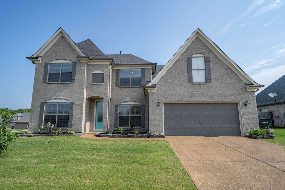 View of front of home with an attached garage, concrete driveway, and a front lawn