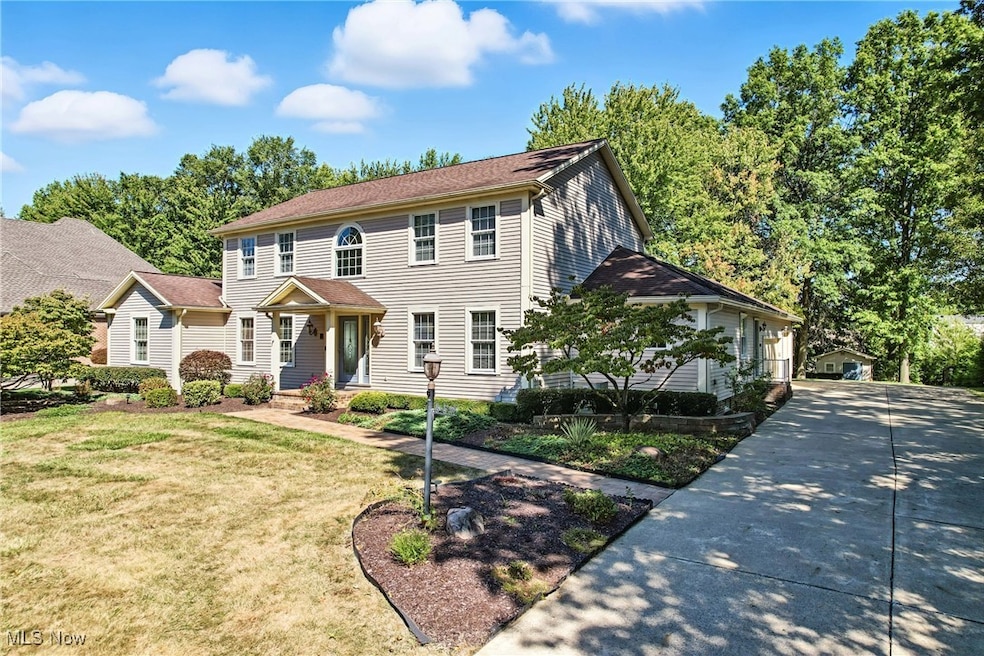 Colonial house with a front lawn, a garage, and concrete driveway