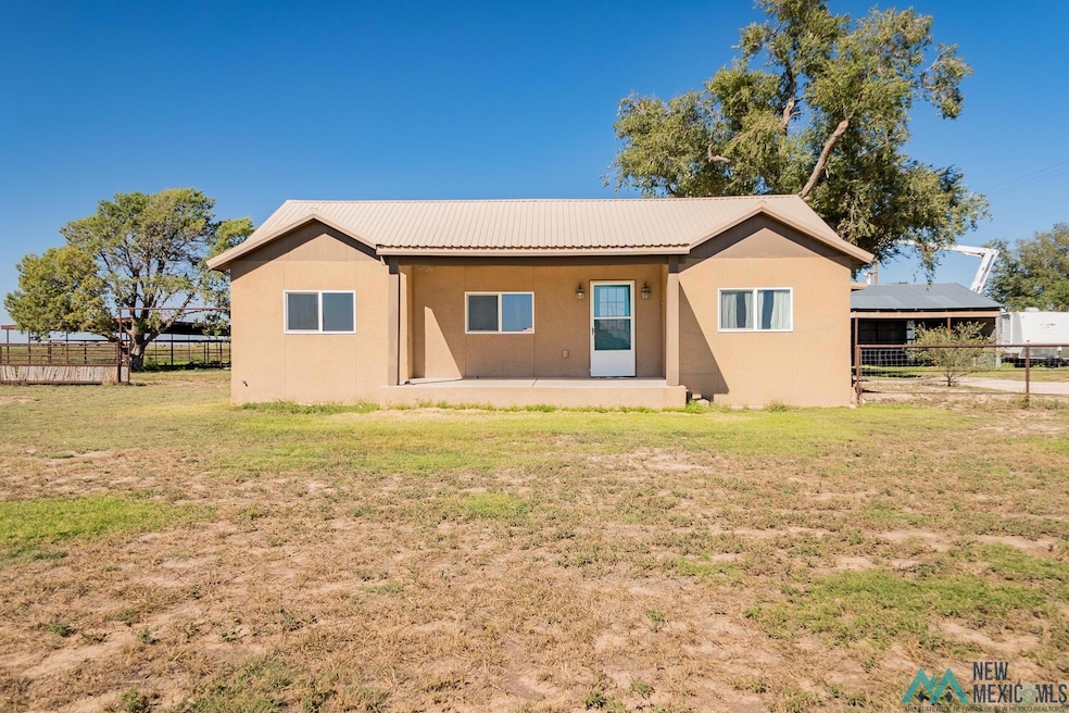 Rear view of property with stucco siding and a metal roof
