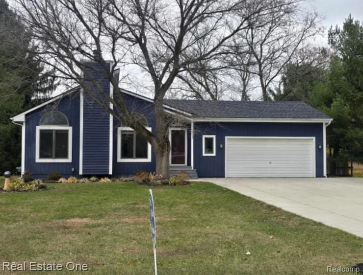 View of front of property featuring concrete driveway, a garage, and a front lawn