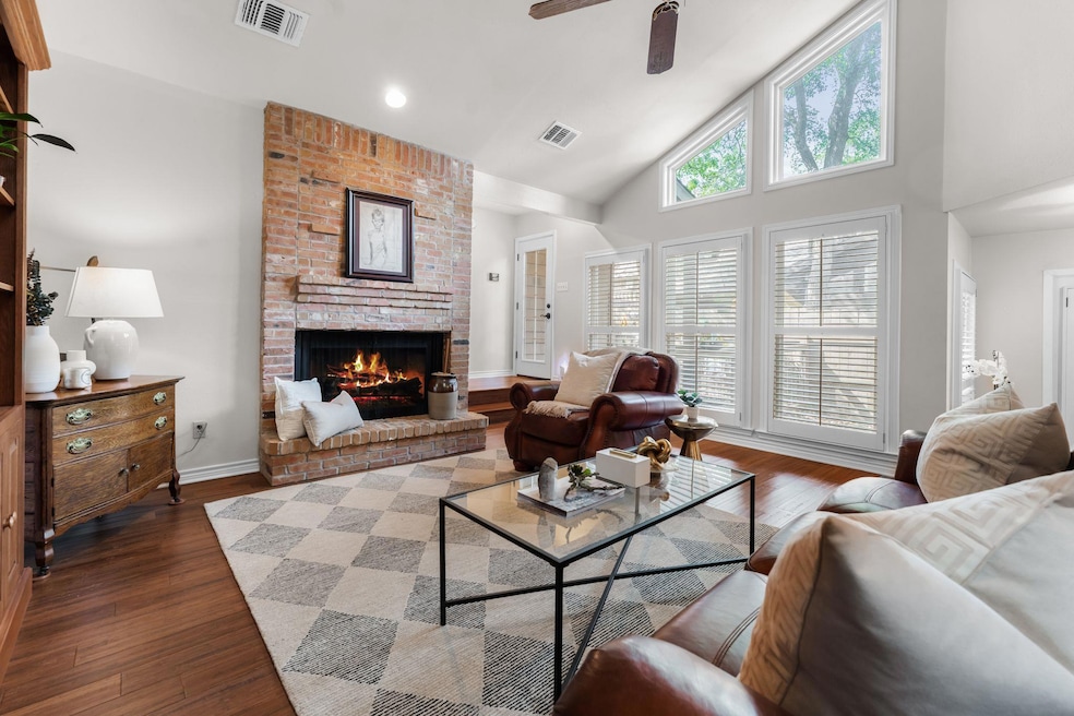 Living room featuring a ceiling fan, high vaulted