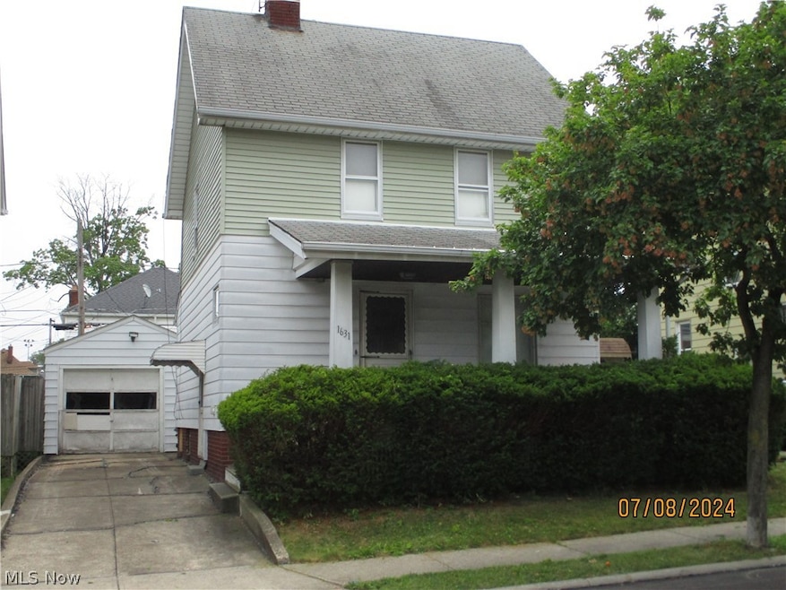View of front of property with a garage and an outbuilding